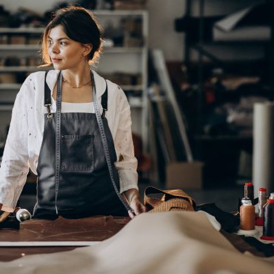 Woman tailor working on leather fabric