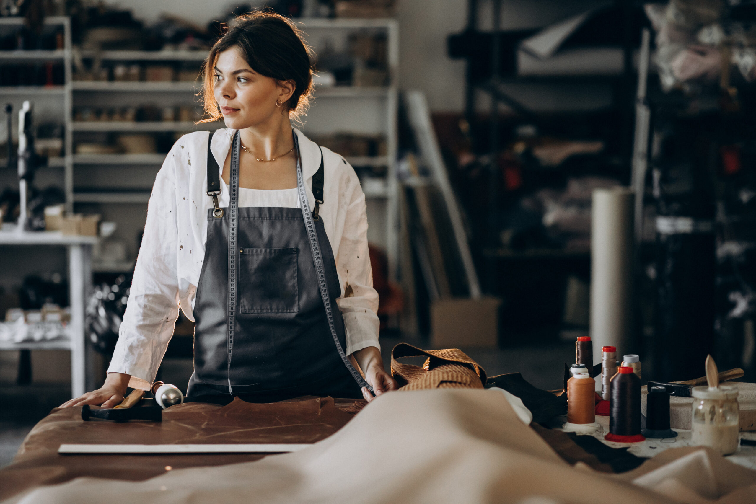 Woman tailor working on leather fabric